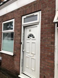 a brick building with a white door and two windows at Alpha house in London