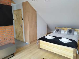 a bedroom with a large bed and a brick wall at Apartament Julia in Maniowy