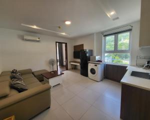 a living room with a couch and a kitchen at Seaside Homestay Beachfront in Vung Tau