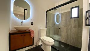een badkamer met een toilet, een wastafel en een spiegel bij Pent house con terraza o departamento con balcón en el centro de oaxaca in Oaxaca City