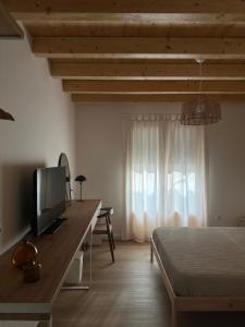 a bedroom with a bed and a desk with a television at Ca Tono Casa Rural in Les Coves de Vinroma
