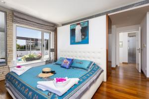 Annabel Beach Palace في لاشي: غرفة نوم بسرير مع قبعة ونافذة