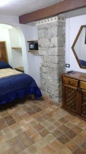 a bedroom with a bed and a stone wall at Hotel Magdalena Colonial in Guanajuato
