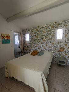 a bedroom with a bed in a room with flowers at Chambre d'hôte au cœur des Alpilles in Mouriès