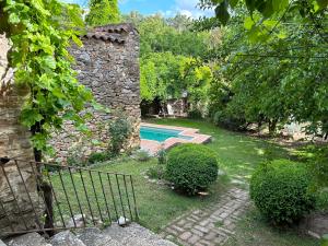 un patio trasero con piscina y un edificio de piedra en Casa Rural en Galaroza en Galaroza