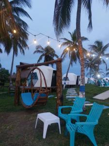 a group of chairs and a hammock and a tent at Aqua Breeze Glamping in San Bernardo del Viento