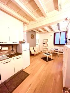 Una cocina con gabinetes blancos y una sala de estar. en RESIDENZA SERENA SUITE-Centro Storico, en Mantua