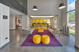- un hall avec des chaises jaunes et un tapis violet dans l'établissement City Express by Marriott Tapachula, à Tapachula