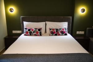 a bed with two pillows and a white bedsheet at Prasino Horio in Arnaia