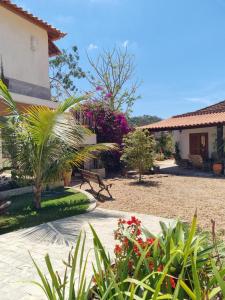 einen Garten mit Pflanzen und Blumen vor einem Haus in der Unterkunft Pousada Pomar de Vassouras in Vassouras