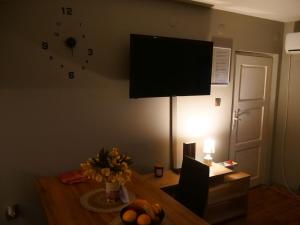a living room with a table with a television on the wall at Cactus house in Ovchartsi