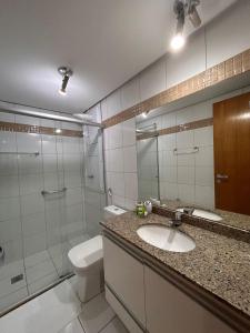 een badkamer met een wastafel, een toilet en een douche bij L336 LB Apartamento aconchegante resort à beira lago in Brasilia