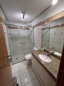 a bathroom with a toilet and a sink and a shower at L336 LB Apartamento aconchegante resort à beira lago in Brasilia