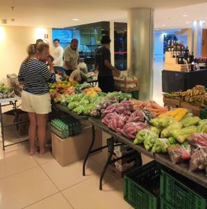 a woman standing at a counter in a grocery store at L336 LB Apartamento aconchegante resort à beira lago in Brasília