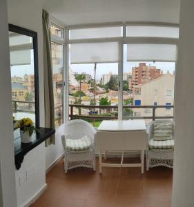 una stanza con tavolo e sedie e una grande finestra di Gamonal 25 a Benalmádena