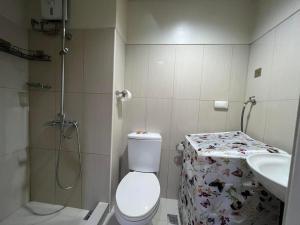 a bathroom with a shower and a toilet and a sink at Shell Residences near Mall Of Asia in Manila