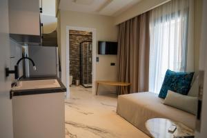 a hotel room with a couch and a window at Fay Suites in Flogita