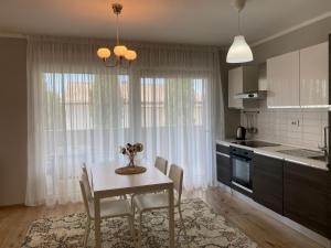 una cocina con mesa y sillas y una cocina con ventanas en M Plus Residence, en Pinezici
