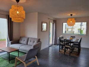 a living room with a couch and a table and chairs at VILLA ROSA PARK in Guipavas