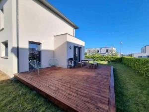 a wooden deck in front of a white building at VILLA ROSA PARK in Guipavas