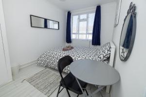 Habitación pequeña con mesa y cama en Nice Rooms near Shoreditch en Londres