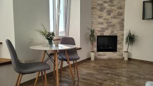 sala de estar con mesa, sillas y chimenea en Апартаменти біля Фортеці, en Kamianets-Podilskyi