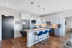 a kitchen with a large island with blue bar stools at Modern Condo on South Slope in Asheville
