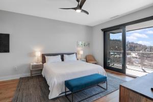 a bedroom with a large bed and a large window at Modern Condo on South Slope in Asheville