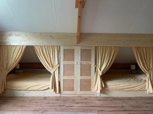 a bedroom with two bunk beds with curtains at Het Riethuis in Holthone +21 photos