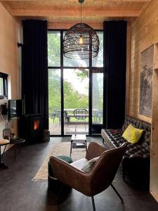 a living room with a couch and a chair at Tiny House Old Oaks in Hulshorst