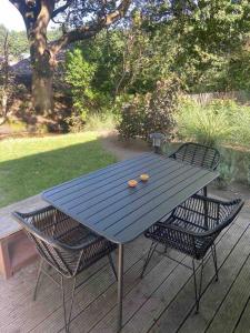 a blue picnic table with two chairs on a deck at Tiny House Old Oaks in Hulshorst