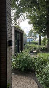 a house with a garden with a window and a bench at Tiny House Old Oaks in Hulshorst