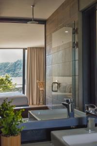 a bathroom with a sink and a bed and a mirror at Cardedeu Hotel Lago de Coatepeque in El Congo