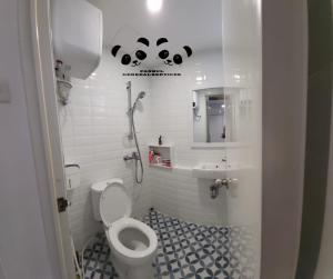 La salle de bains blanche est pourvue de toilettes et d'un lavabo. dans l'établissement Apartment Kalibata City by PanBul, à Jakarta