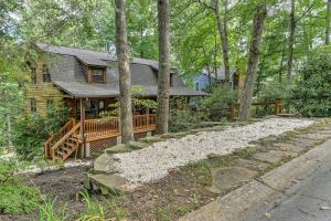 een blokhut in het bos met een veranda en bomen bij Charming Renovated Cabin with Fireplace in Arden