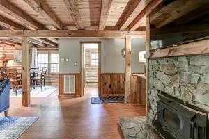 an open living room with a stone fireplace at Charming Renovated Cabin with Fireplace in Arden +29 photos