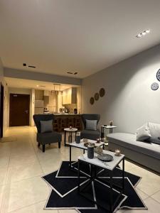 a living room with a couch and tables and a kitchen at aladnan Chalet alraha village in Aqaba