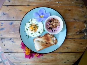 a plate with eggs and toast and a bowl of food at Hotel Casa de Verano - Solo adultos - in Santa Fe de Antioquia