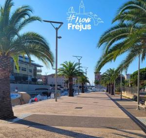 a sidewalk with palm trees on a beach at T2/T3 duplex à Port Frejus proche de la mer in Fréjus