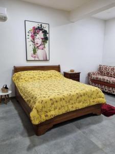 a bedroom with a bed with a yellow blanket at Pousada Pomar de Vassouras in Vassouras