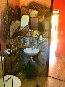 een badkamer met een stenen muur en een wastafel bij Espaço Ecológico e Pousada Terra Betania in São João da Aliança