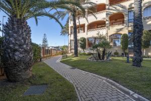 einen Gehweg vor einem Gebäude mit Palmen in der Unterkunft Los Gavilanes by Ĥ in Isla Canela