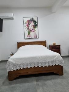 1 cama en un dormitorio con una foto en la pared en Pousada Pomar de Vassouras, en Vassouras