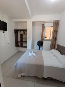 佛羅安那波里的住宿－Residencial Caramujo，一间卧室配有一张大床和毛巾