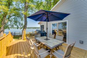 a table and chairs with an umbrella on a deck at Waterfront Lodi Vacation Rental on Lake Wisconsin! in Lodi