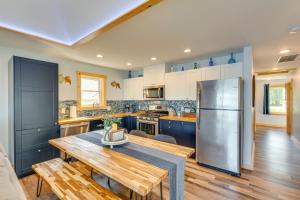 a kitchen with a wooden table and a stainless steel refrigerator at Waterfront Lodi Vacation Rental on Lake Wisconsin! in Lodi