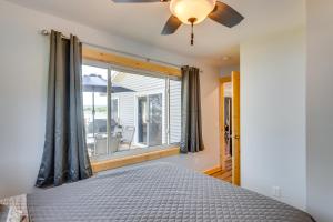 a bedroom with a bed with a ceiling fan and a window at Waterfront Lodi Vacation Rental on Lake Wisconsin! in Lodi