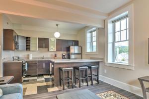 a kitchen with wooden cabinets and bar stools at Historic King James Unit 1 in Asheville