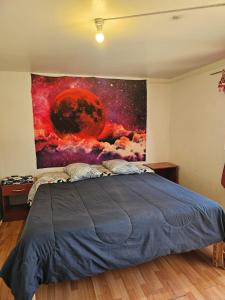 1 dormitorio con 1 cama con una pintura en la pared en el valle, en Copiapó