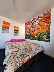 um quarto com uma cama e pinturas na parede em el valle em Copiapó